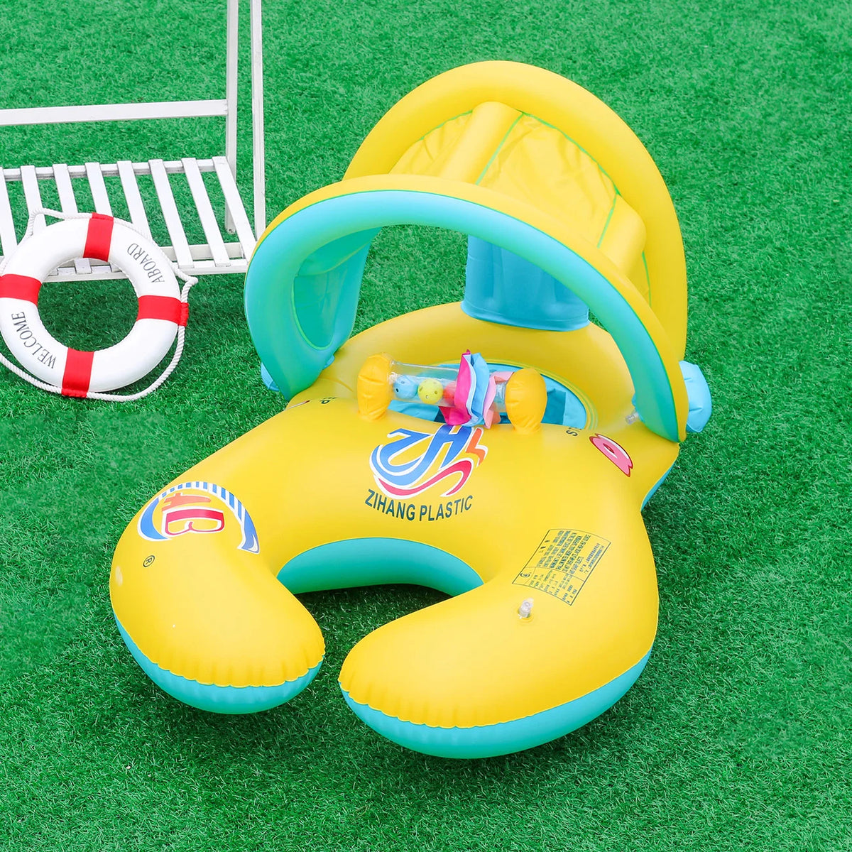 Yellow inflatable pool lounger for two with a sun canopy and backrest resting on green grass.