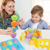 A set of colorful matching eggs for toddlers, including yellow, green, orange, and purple shapes, displayed on a blue tray.