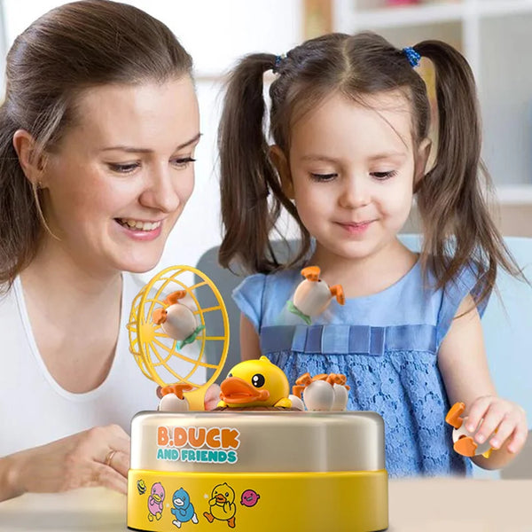 A woman and a girl are interacting with an interactive Bouncing Duck toy.