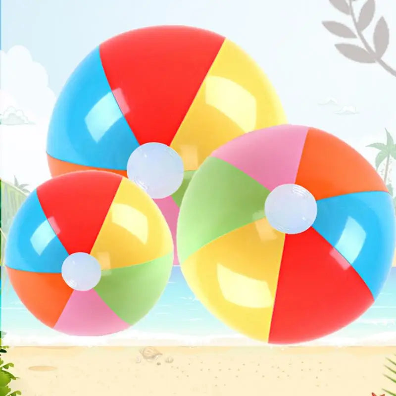 A set of six colorful rainbow inflatable beach balls floating above a sandy beach background.