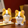 A fluffy yellow and white Corgi plush pillow sitting on a wooden surface.