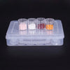 A clear plastic storage container holds six small glass vials filled with colored powders: pink, white, purple, and orange.