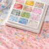 A white tray holds a 50-piece set of gradient acrylic beads in various colors and shades scattered on pink paper.