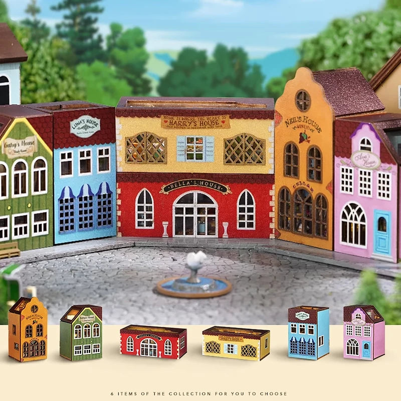 A collection of six wooden miniature dollhouse kits in various colors and styles displayed in front of a backdrop of a villag