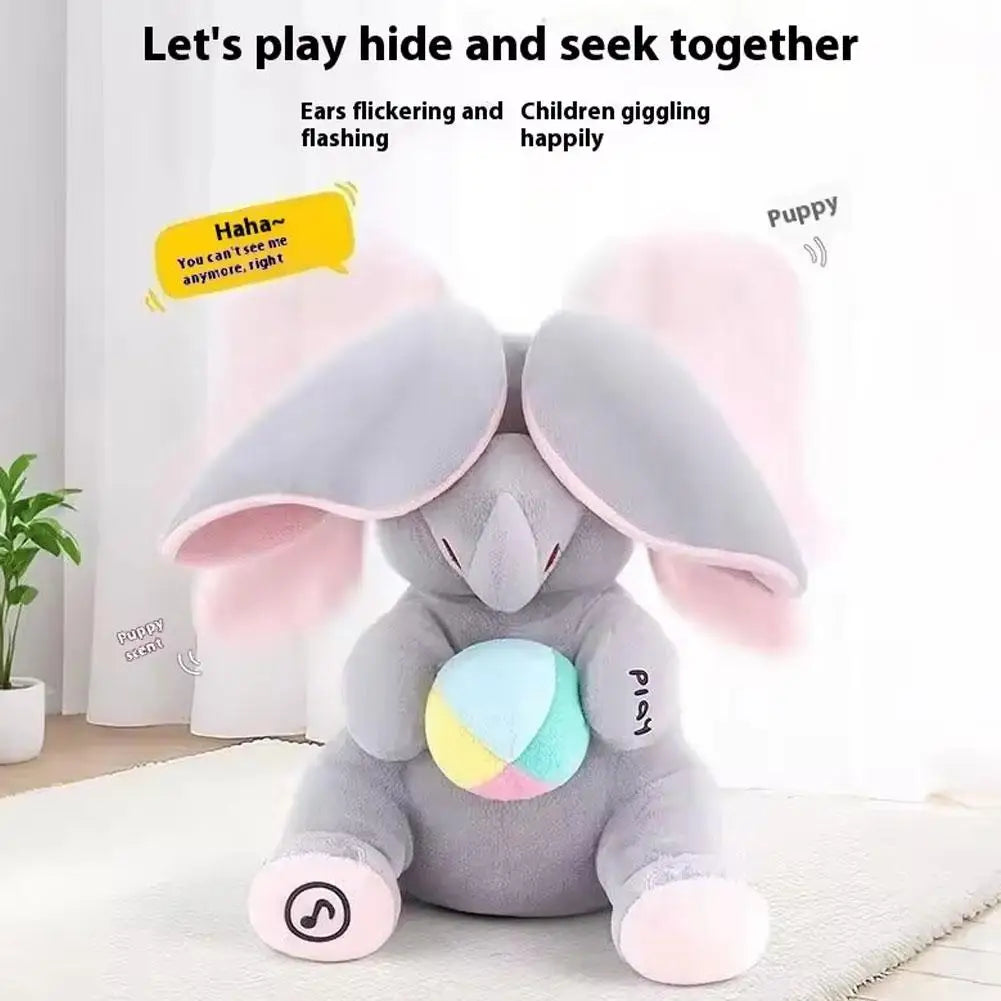 Peluche d'éléphant gris avec des oreilles roses assis sur un tapis blanc.