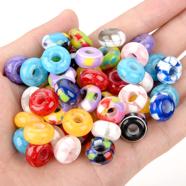Eine Hand hält eine Sammlung von mischendfarbigen Harz-Spacer-Perlen für DIY-Schmuck.
