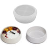 A set of two white round silicone molds for planters and decor, one empty and one filled with dried flowers.