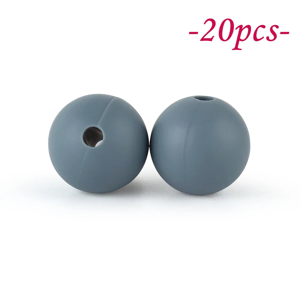 Two round, smooth gray silicone beads are shown against a white background.