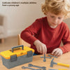 A young child is using a yellow and gray tool box set for pretend play, surrounded by various tools and accessories.