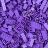 A close-up view of many small purple plastic building blocks scattered on a surface.