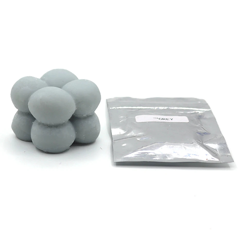 A pile of grey candle dye chips for soy wax, beeswax, and paraffin wax.