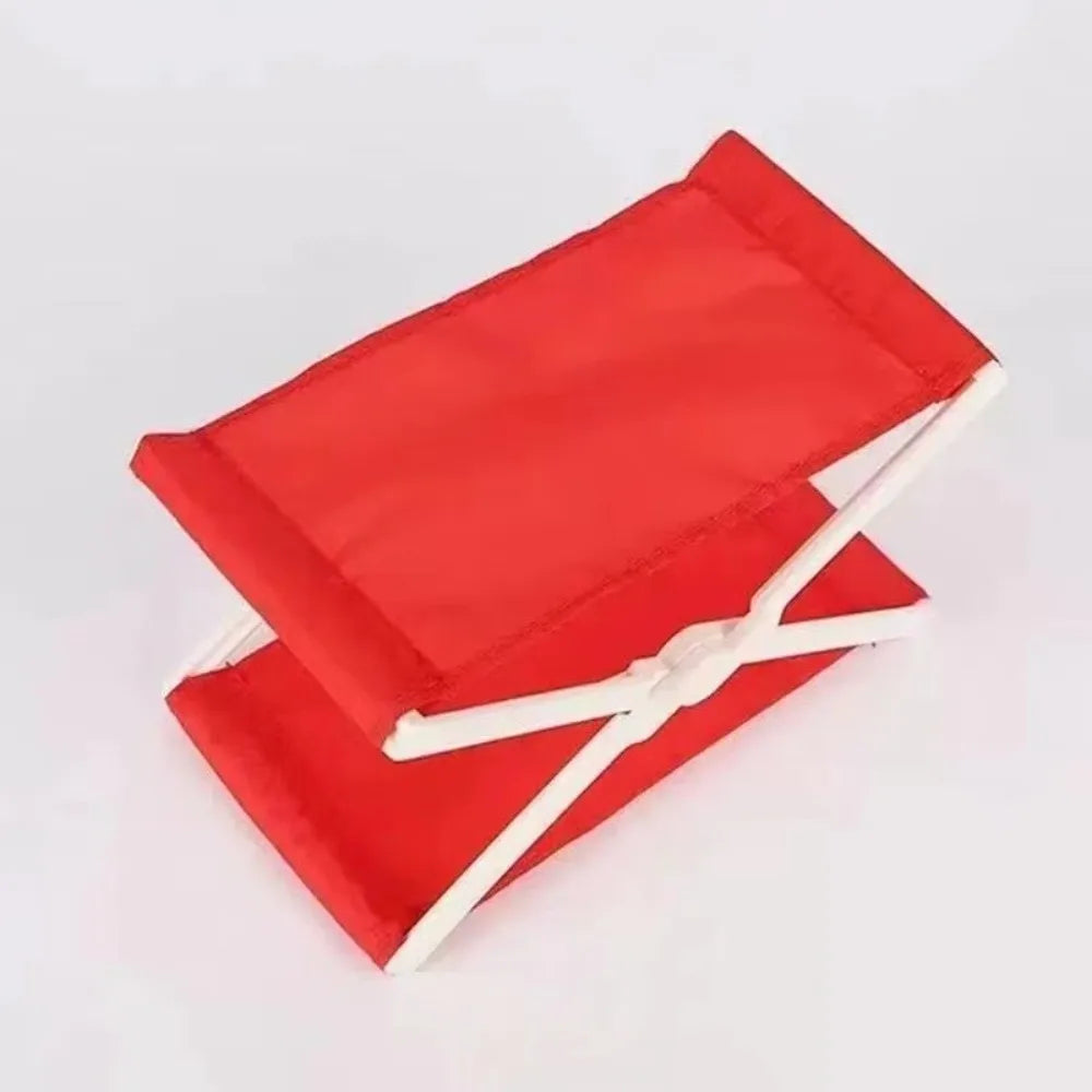 A red foldable camp pillow with white straps, shown flat.