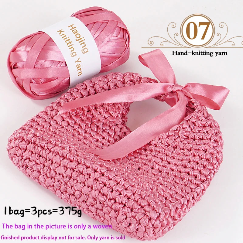 Pink satin ribbon yarn and a finished pink knitted heart bag display