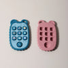 A pair of phone-shaped silicone teethers, one blue and one pink, designed for babies.