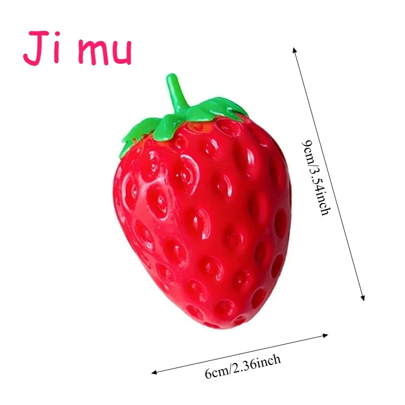 A bright red strawberry squishy stress ball with a green stem and leaves.