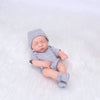 A realistic soft vinyl baby doll with a newborn outfit set wearing a gray striped onesie and matching pants.