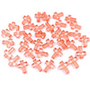 A pile of small, translucent pink acrylic cross beads for jewelry making.