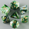 A set of green and white acrylic dice showing various numbers for tabletop gaming.