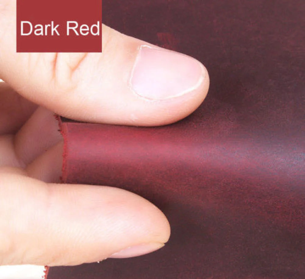 A hand is pressing a piece of dark red leather material, showing the texture and color for crafting.