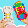 Eine Hand hält ein buntes Schuh mit Schnürsenkeln und eine Papierform eines Schuhs für eine Feinmotorik-Aktivitäts-Kit für Kl
