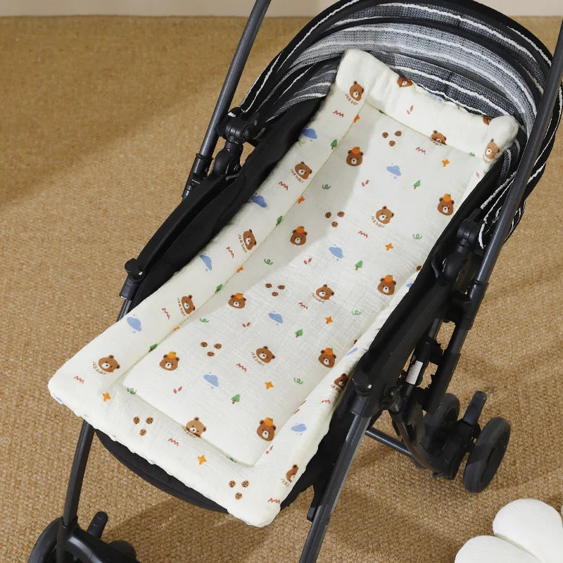 Matelas en coton doux avec un motif de petits ours et nuages, montré à l'intérieur d'une poussette noire pour bébé.