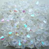 A pile of clear, faceted glass bicone beads for jewelry making.