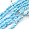 A strand of light blue heart-shaped acrylic beads for jewelry making laid out on a white surface.