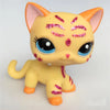 A yellow Littlest Pet Shop style cat figure with pink glitter accents and large blue eyes.