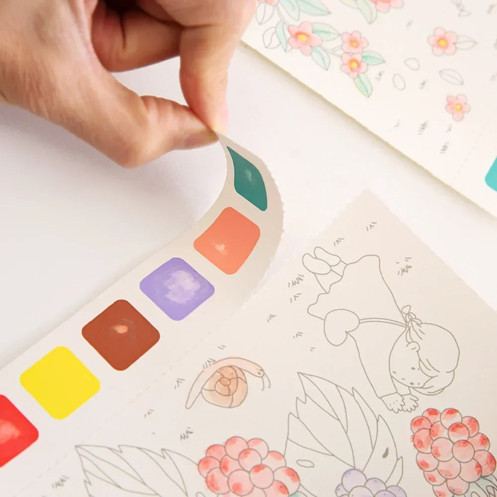 A hand is pointing at a color palette section in a creative watercolor painting book for kids featuring fairy tale and animal