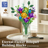 A bouquet of colorful flowers made from building blocks displayed in a glass vase on a table.