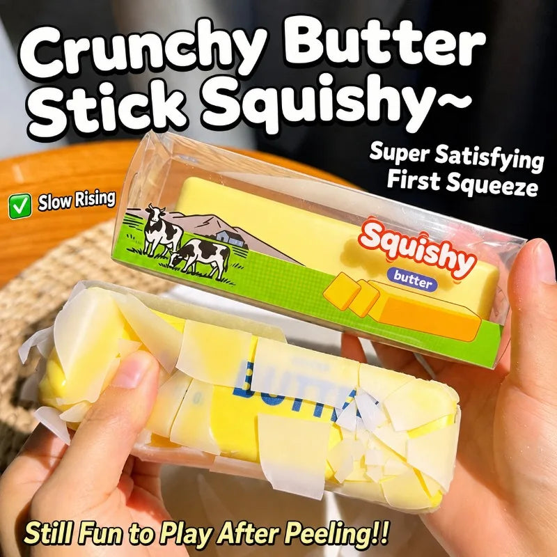 A hand holds a squishy butter stick toy showing the yellow butter bar being peeled.