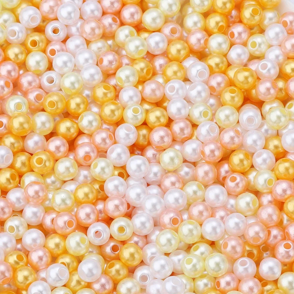 A close-up of colorful imitation pearl beads in shades of pink, peach, and yellow.