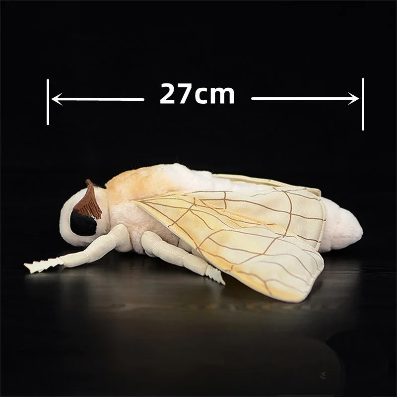 A light beige silk moth plushie with translucent wings is shown against a dark background.