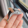 Silver rhinestone turtle brooch pin being held in a hand