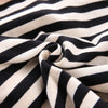 A close-up of a black and white striped fabric, likely a kids' summer outfit set.