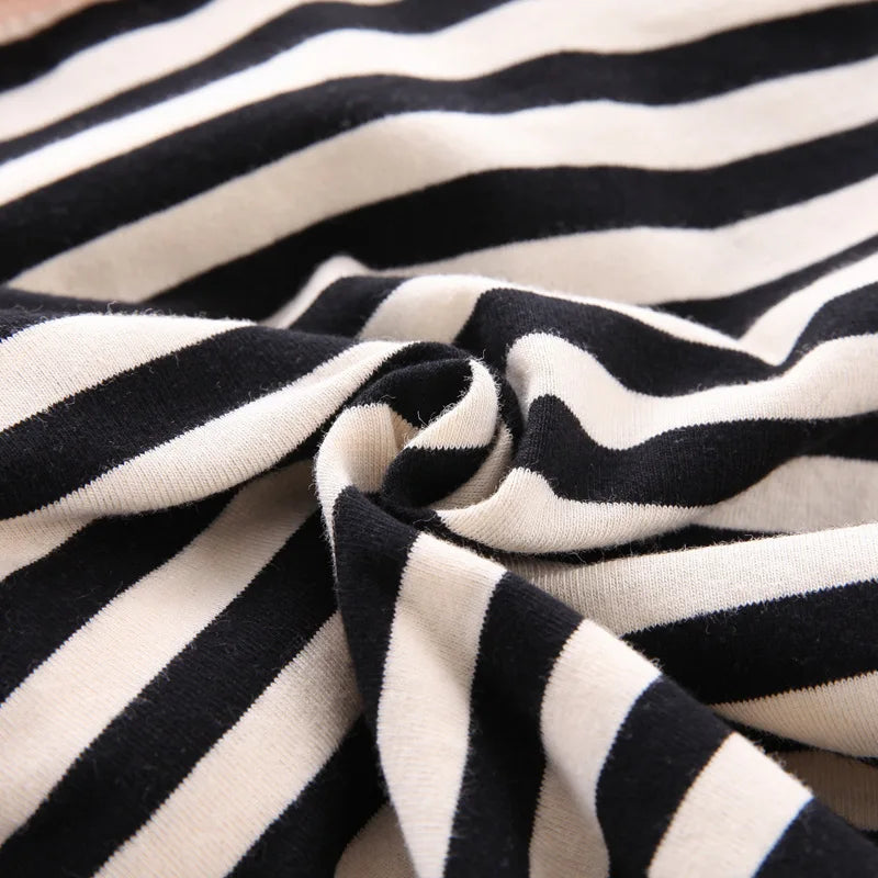 A close-up of a black and white striped fabric, likely a kids' summer outfit set.