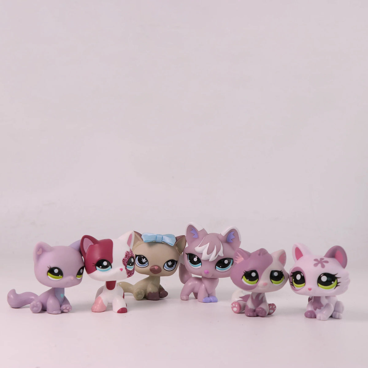 A collection of Shorthair Cat Bobble Head figurines in various colors and poses.