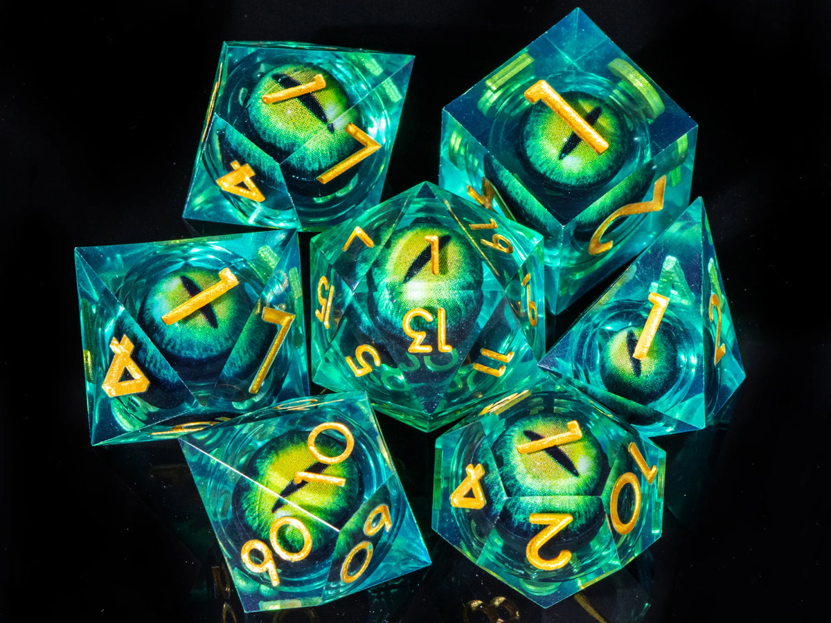 A collection of seven liquid core resin polyhedral dice in shades of teal and green resting on a dark surface.