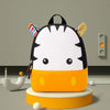 A yellow and black striped animal-themed backpack with elephant ears sits on a round orange stand.