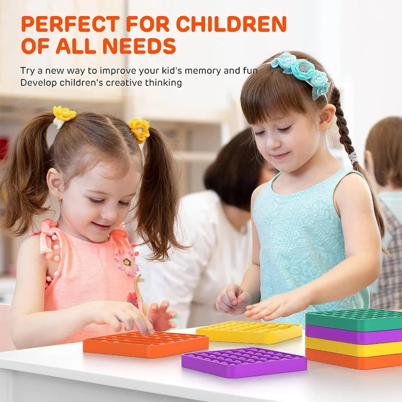 A child is playing with colorful pop bubble sensory fidget toys on a white table.