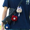 A dark blue t-shirt features a black bag clip with three plush blind boxes: a purple, a beige, and a red fluffy animal.