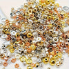 A pile of mixed color acrylic spacer beads in gold, silver, and rose gold tones for jewelry making
