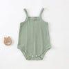 A light sage green lightweight cotton strappy romper for babies with a subtle textured pattern.