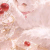 A fluffy white kitten sits near a delicate cake decorated with strawberries and is surrounded by sparkling elements.