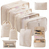A set of beige travel packing cubes and storage bags for organizing items.