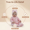 A pink soft body baby doll with a bow, showing details like soft skin, hand-painting, and multiple layers.