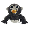 A plush toy of a monkey with large eyes and a wide, toothy grin.