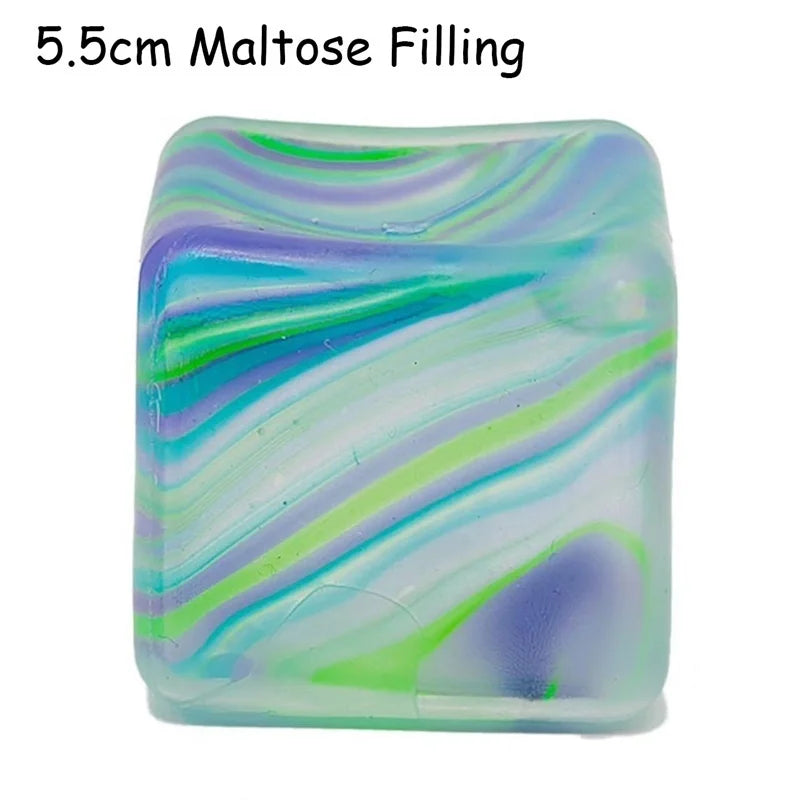 A translucent cube toy filled with maltose, displaying swirling shades of blue, green, and purple.