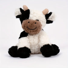 A soft, cuddly cow plush toy with black and white fur and brown accents.