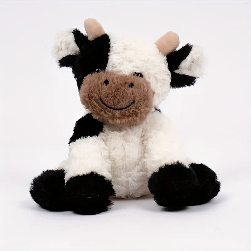 A soft, cuddly cow plush toy with black and white fur and brown accents.